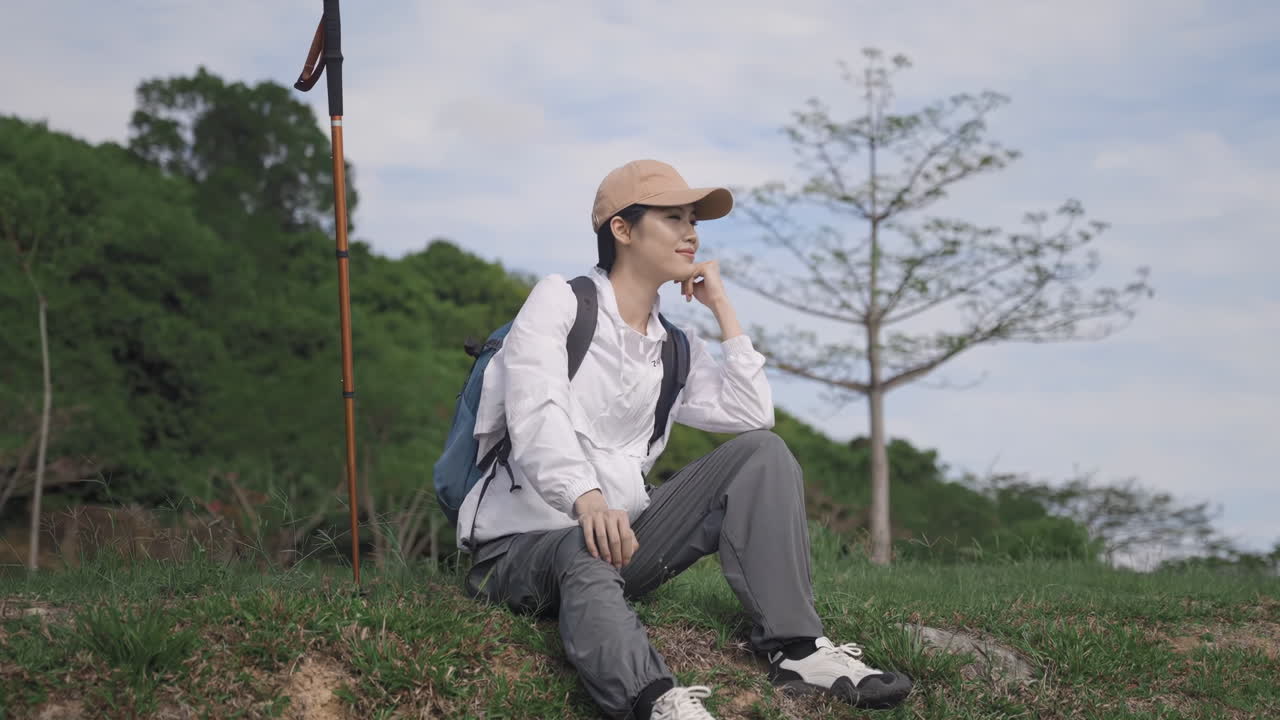 Pendaki gunung dan pejalan ransel dengan gaya hidup aktif dilengkapi tongkat trekking dan ransel sedang beristirahat, menikmati suasana alam, duduk di puncak gunung setelah berjalan menyusuri jalur hutan dan mendaki jalan setapak melalui lanskap pegunungan Alpen
