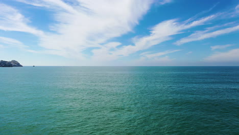 drone shot low over the turquoise sea surface, sunny day in baja california, usa