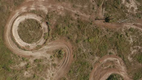 Aerial-drone-shot-of-fallen-tree-and-circle-racing-track