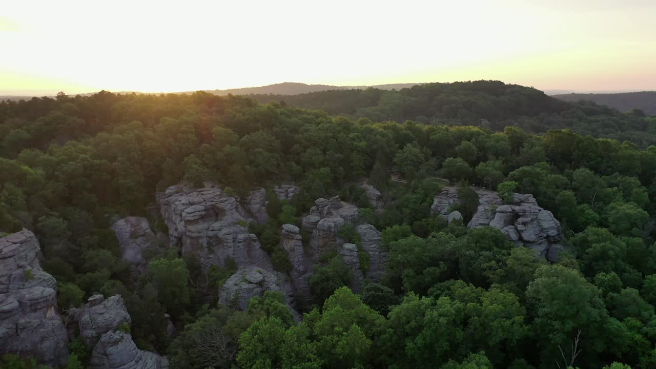 bosque que crece sobre un acantilado rocoso con majestuoso amanecer, vista aérea