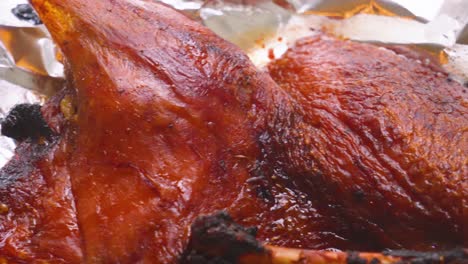 delicious half duck with crispy skin fresh after cooking ready to be shredded and put into pancakes or other meal types. cooked bird with textured close up details.