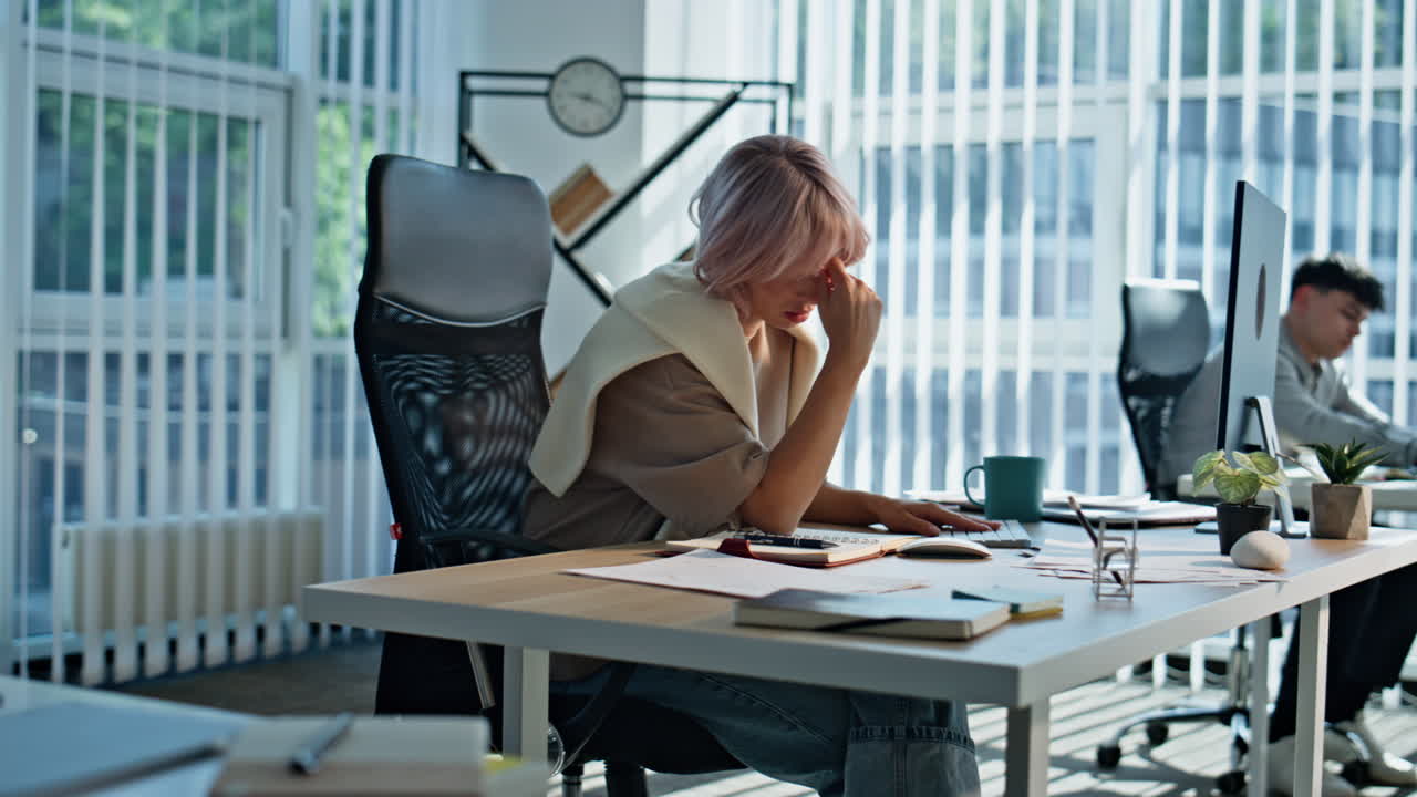 Exhausted manager noticing copybook working in open space. Woman touching head