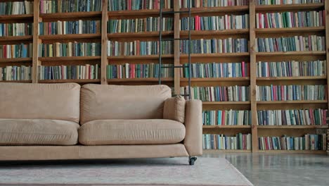 happy guy from the middle east sits on a sofa in the library.