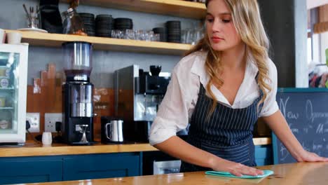 young waitress is cleaning the counter