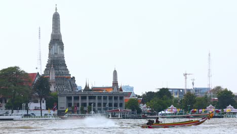 long-tail boat travels past iconic wat arun temple