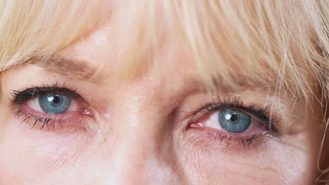 close up of eyes as mature woman looks at camera in studio