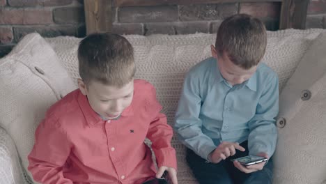 sweet little boys play video games on modern gadgets