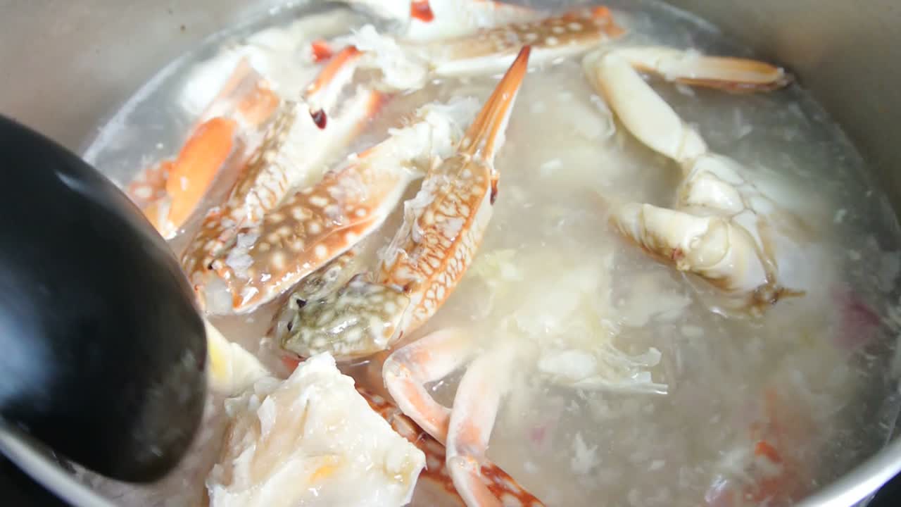 The cooks cook crab soup. Crab soup is cooked in a saucepan and stirred slowly for cooking evenly. Cooking ingredients included in stages