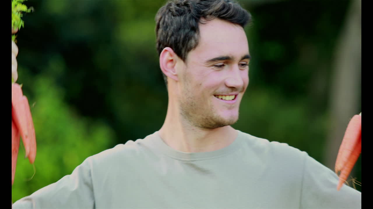 당근을 들고 있는 행복한 잘생긴 남자