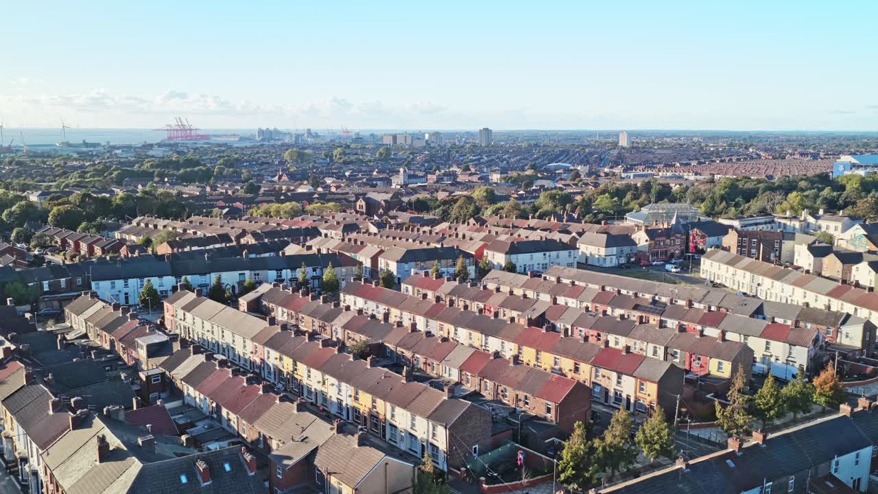 Cinematic aerial drone footage of the neighbourhood surrounding Liverpool FC’s iconic Anfield stadium, captured during sunset. The golden-hour light highlights the residential streets