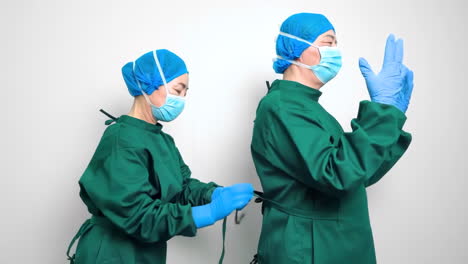 assistant helping doctor operating in surgery room in hospital indoors