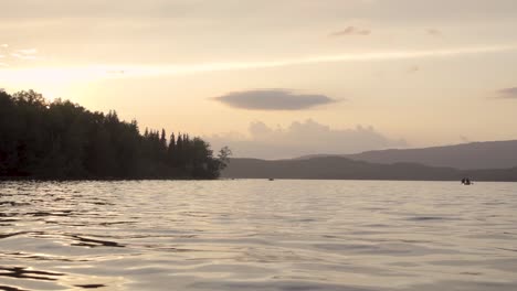 slow motion. a couple canoeing at sunset on umbagog national wildlife refuge.