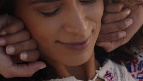 retrato en primer plano de una mujer hermosa y feliz disfrutando de la libertad explorando la espiritualidad sintiendo esperanza en la pacífica orilla del mar al atardecer con el pelo soplado por el viento