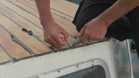 recortar el sellador tapajuntas sika flex mastic en el borde de la cabina, bote de madera