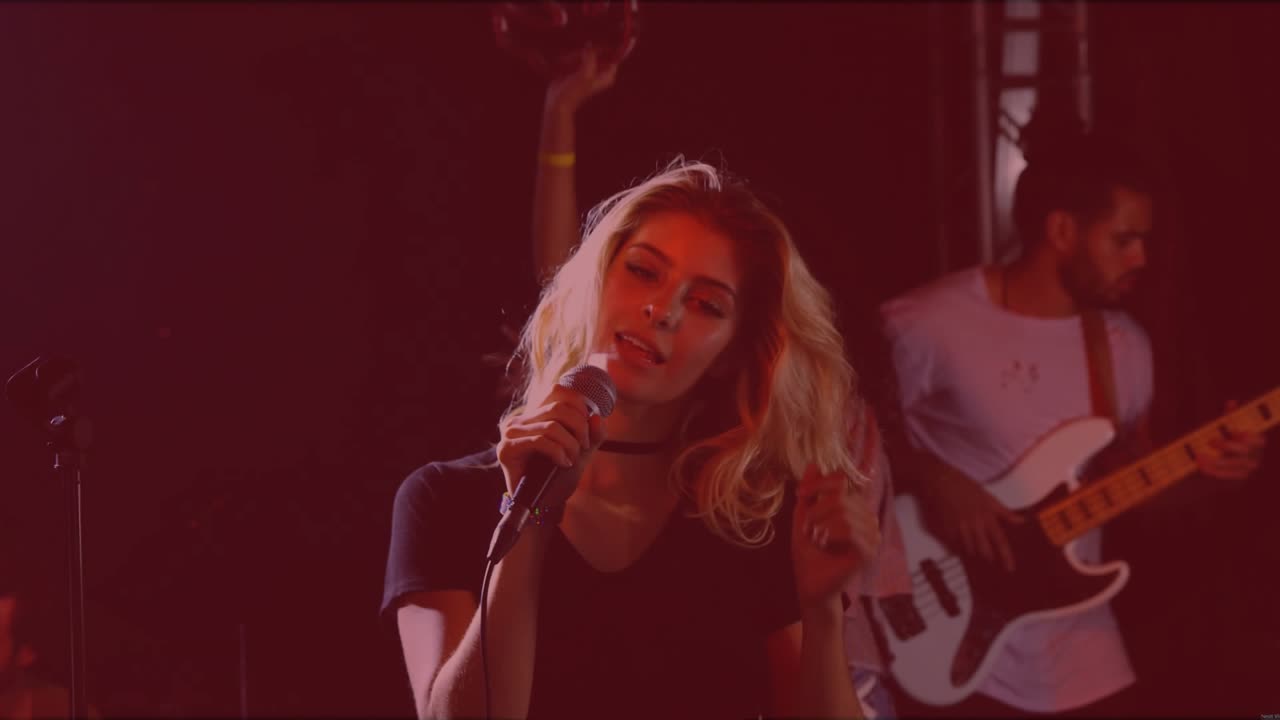 Lead singer singing into mic and flipping hair, initiating floating hearts during music set