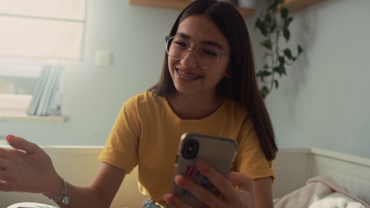 adolescente caucásica haciendo una videollamada mientras pasa tiempo en el dormitorio