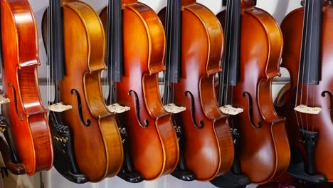 a row of violins hanging in a music store