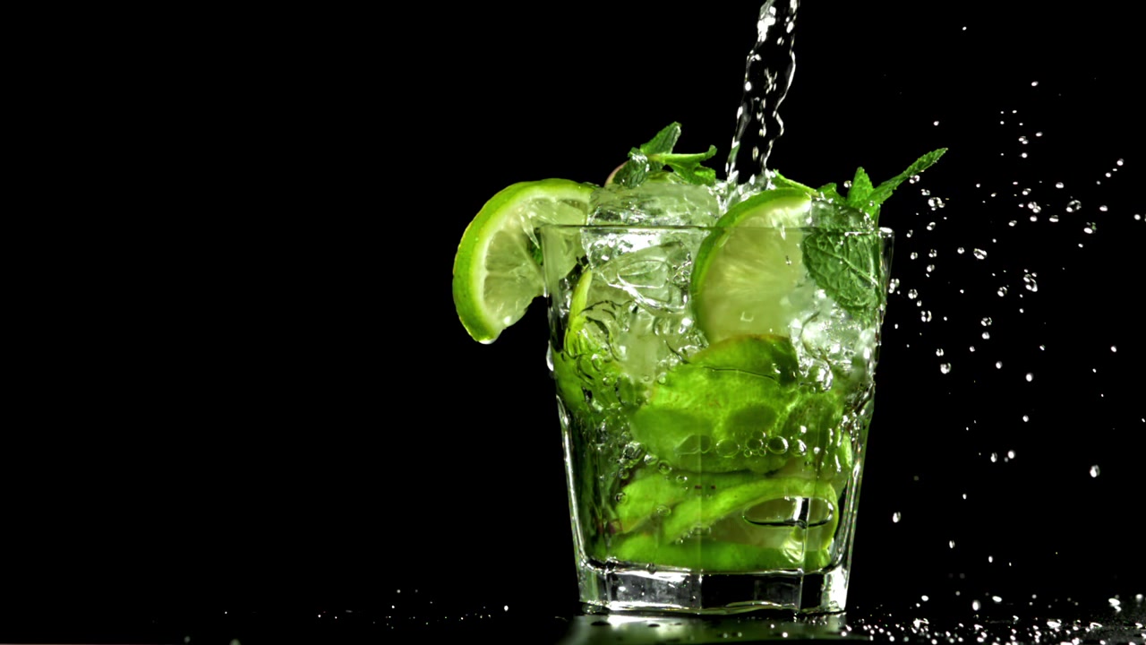 Virkistävän mojito-cocktailin kaataminen limellä ja mintulla hidastettuna