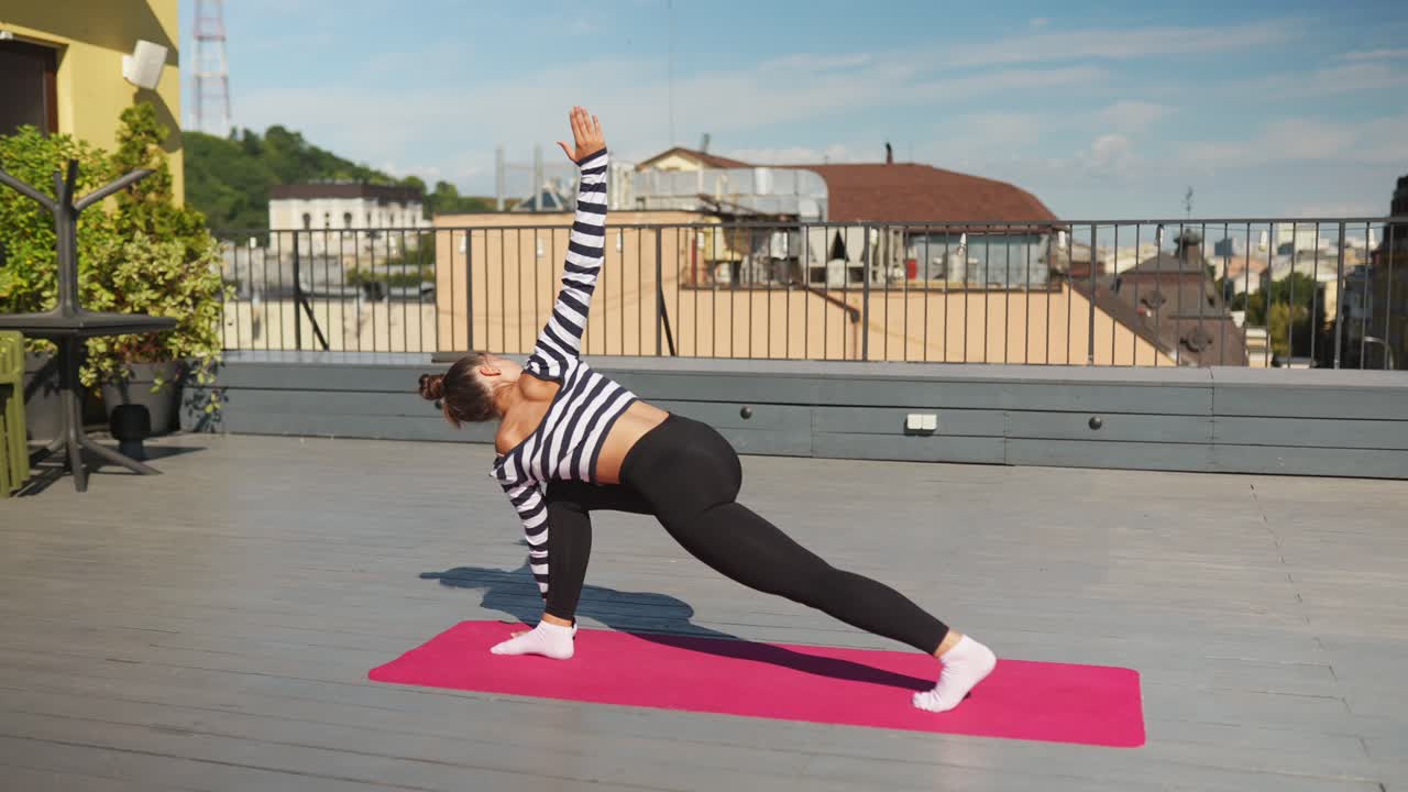 mujer practicando yoga en un techo