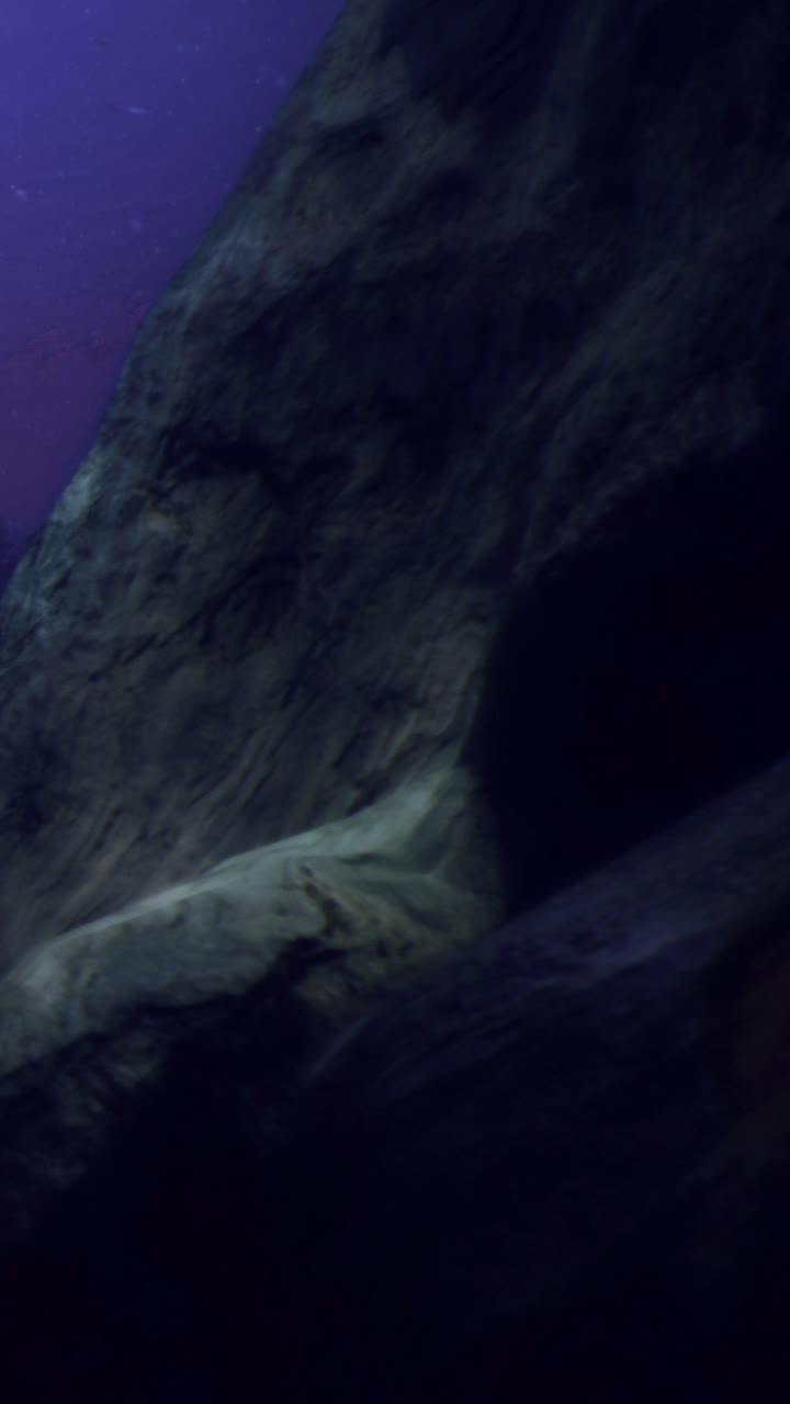 Mysterious underwater scene showcasing rocky formations and deep blue hues