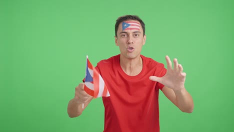 man cheering for puerto rico screaming and waving a national flag
