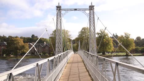 puente peatonal moderno que cruza un río en inverness, escocia en las tierras altas