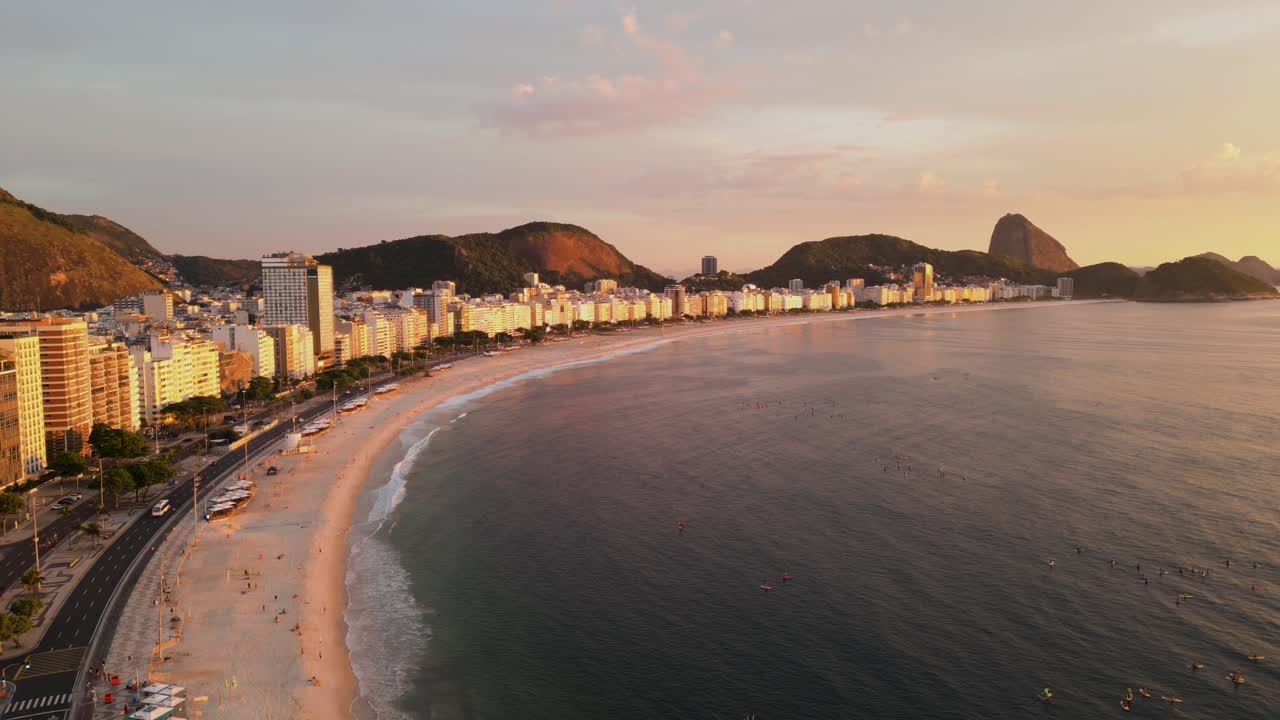 Rio de Janeiron kaupungin horisontin ilmakuva dronella auringonnousun aikaan Brasiliassa, taustalla näkyvä valtameri ja kultainen aamuvalo kaupunkimaiseman yllä.