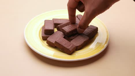 coger a mano el chocolate oscuro de un plato,