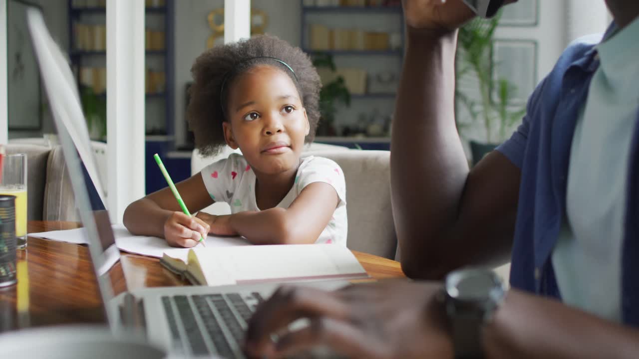 Video of african american father and daughter using laptop and learn