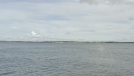 Low-overcast-aerial-flyover-of-concrete-ocean-harbor-breakwater