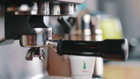 hand inserting portafilter into grinder in slow motion