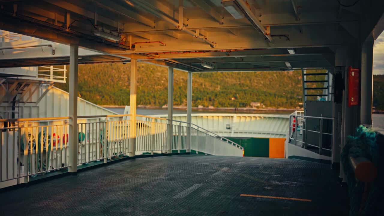 Auringon lämmin hehku valaisee lautan kannen, taustalla maisema, Bognesissa, Hamarøyn kunnassa, Nordlandin läänissä, Norjassa – POV-kuva.
