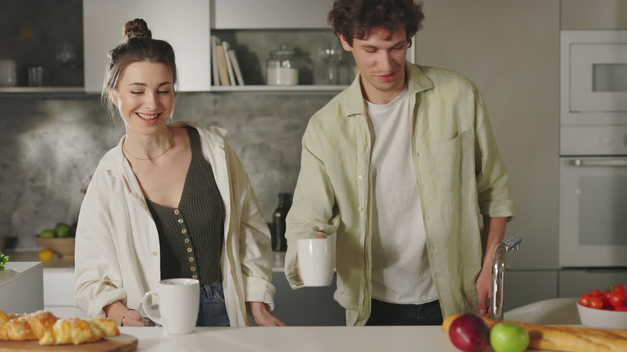 Coppia che prepara caffè e colazione in una cucina moderna