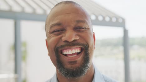 portrait of happy african american businessman looking at camera and smiling at office, slow motion