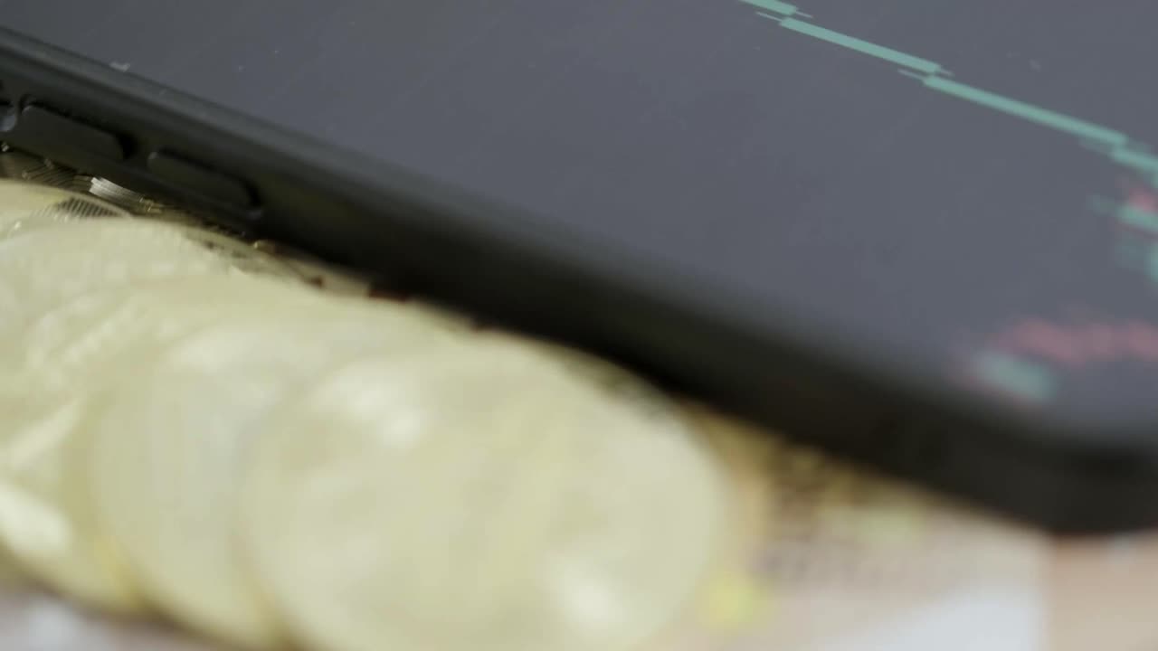 Bitcoin gullmynt roterer med smarttelefon som handler på nett, grønn trendgraf for aksjemarkedet