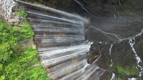 vertical aerial tilts at top of unique tumpak sewu waterfall on java