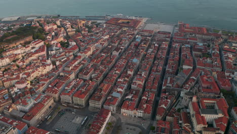 Close-up-rotating-aerial-view-of-rows-of-colorful-houses-by-the-sea-in-Lisbon-city-center