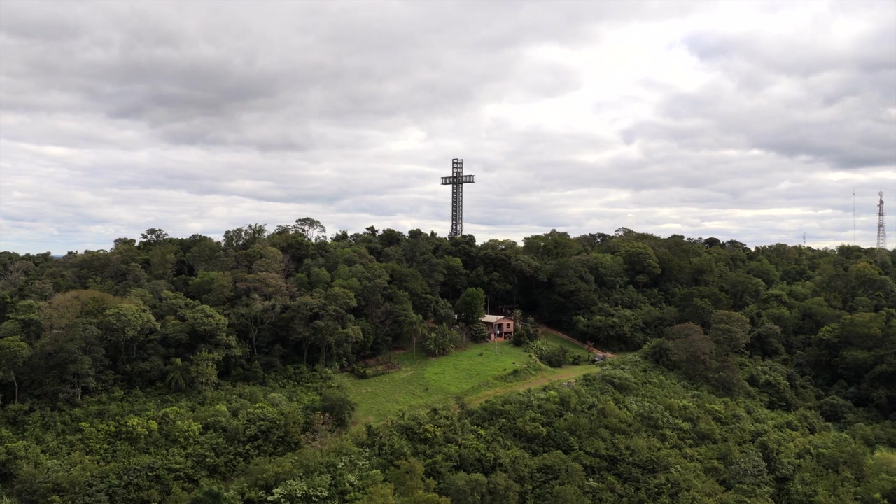 Un imponente monumento a croce si erge in mezzo a una fitta giungla a Santa Ana, Misiones, Argentina. Cieli coperti creano uno sfondo drammatico. Ideale per documentari di viaggio o servizi culturali.