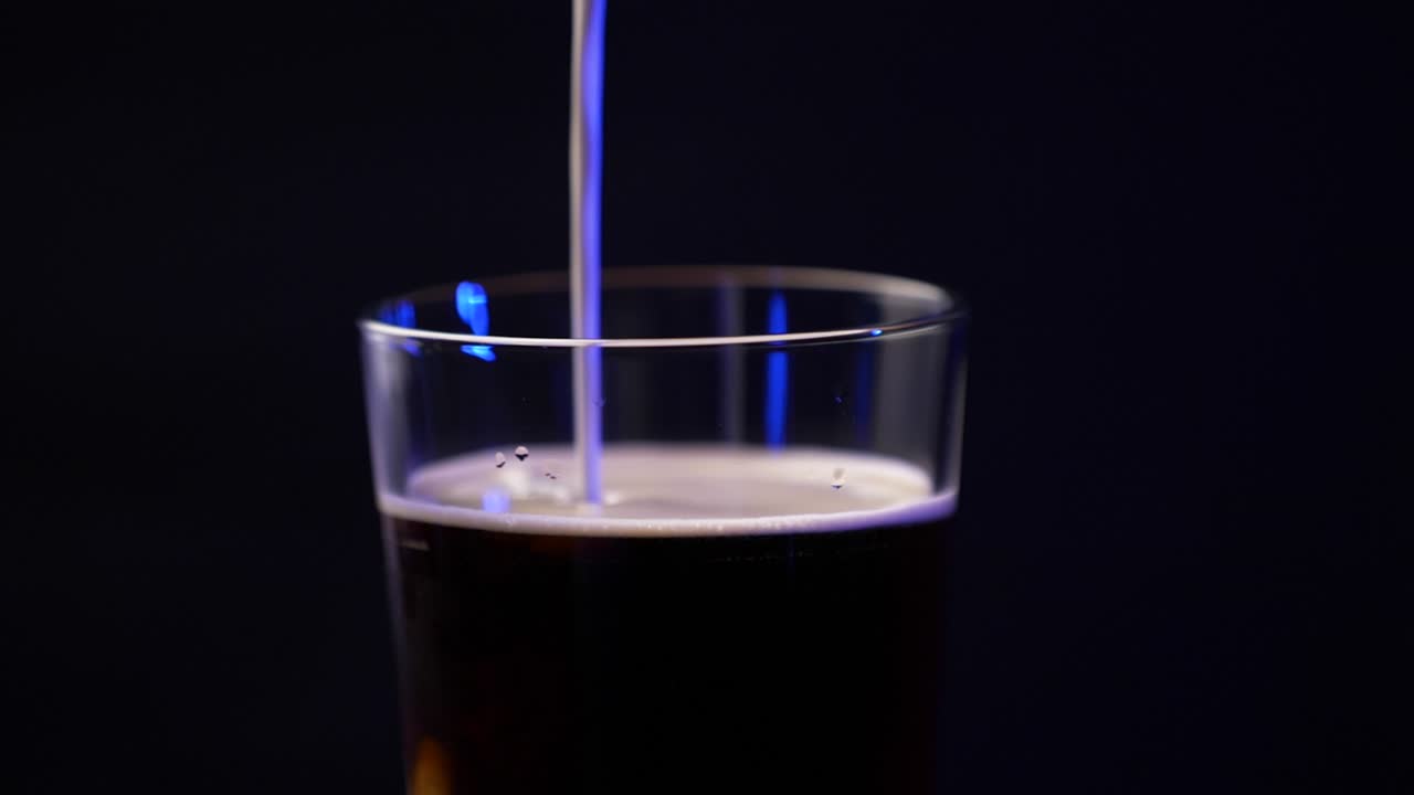 Creamer being poured into a cold brew coffee in a pint glass