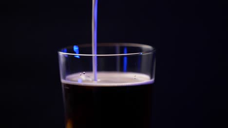la crema se vierte en un café frío en un vaso de pinta