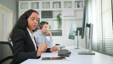 attractive businesswoman wearing headset looking at computer and make video conference with customer. pretty girl customer service manager speaking to customer via web cam. customer service