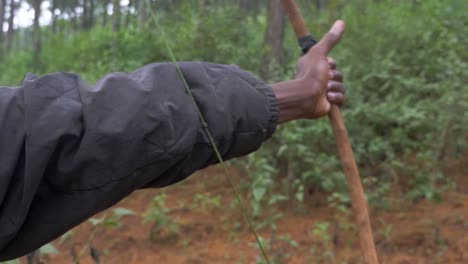 A-slow-motion-close-up-shot-of-an-African-man-shooting-a-traditional-hunting-and-bow-and-arrow