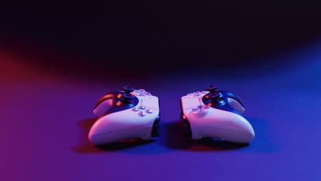 Video of close up of video game pad controllers with copy space on neon background
