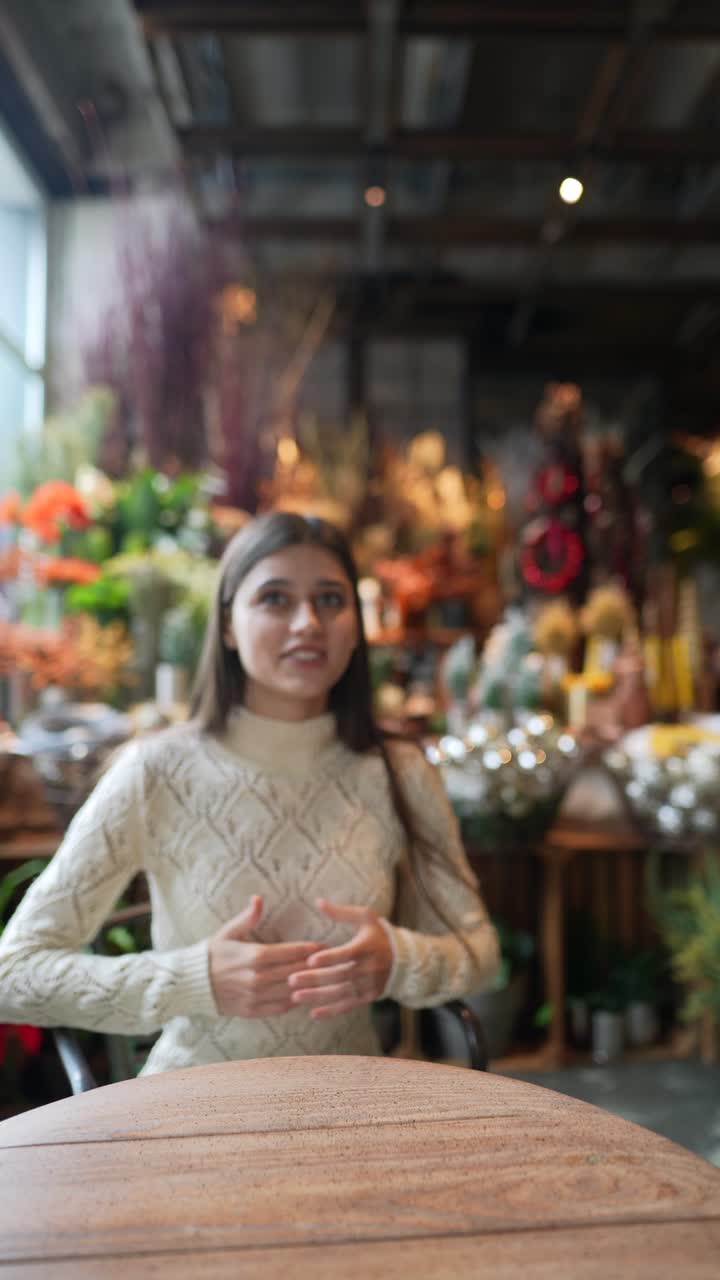 꽃 과 크리스마스 장식품 을 가진 카페 에 앉아 있는 여자