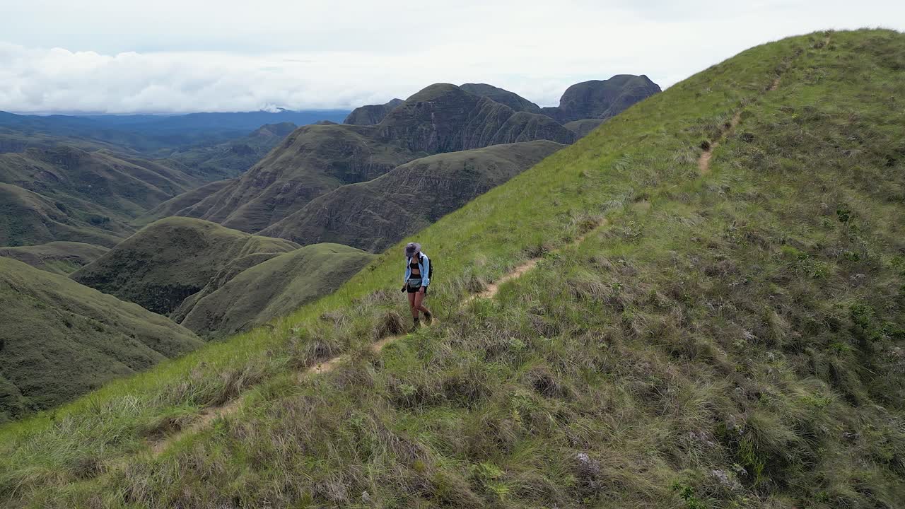 여성 배 여행객이 볼리비아의 코도 드 로스 안데스 (codo de los andes) 에 있는 mtn 리지 아래로 산책합니다.