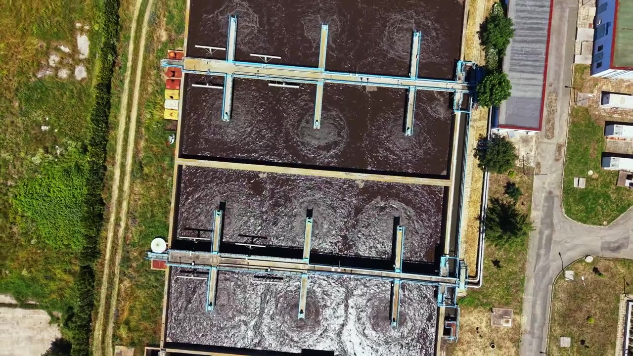 Wastewater treatment plant operates efficiently in urban area during daylight with tanks and machinery in view
