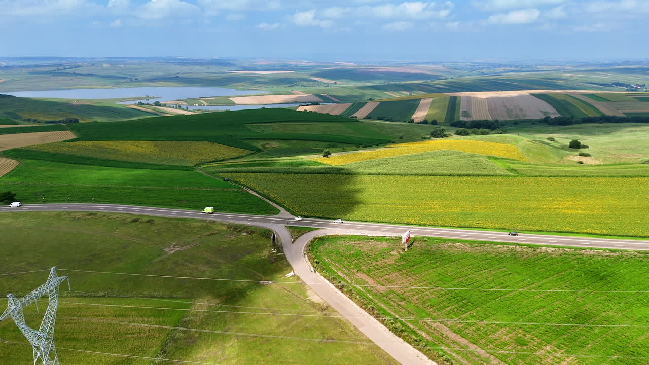 Colorful farmlands with road junction. Aerial panorama of cultivated fields and highways crossing rural Romania
