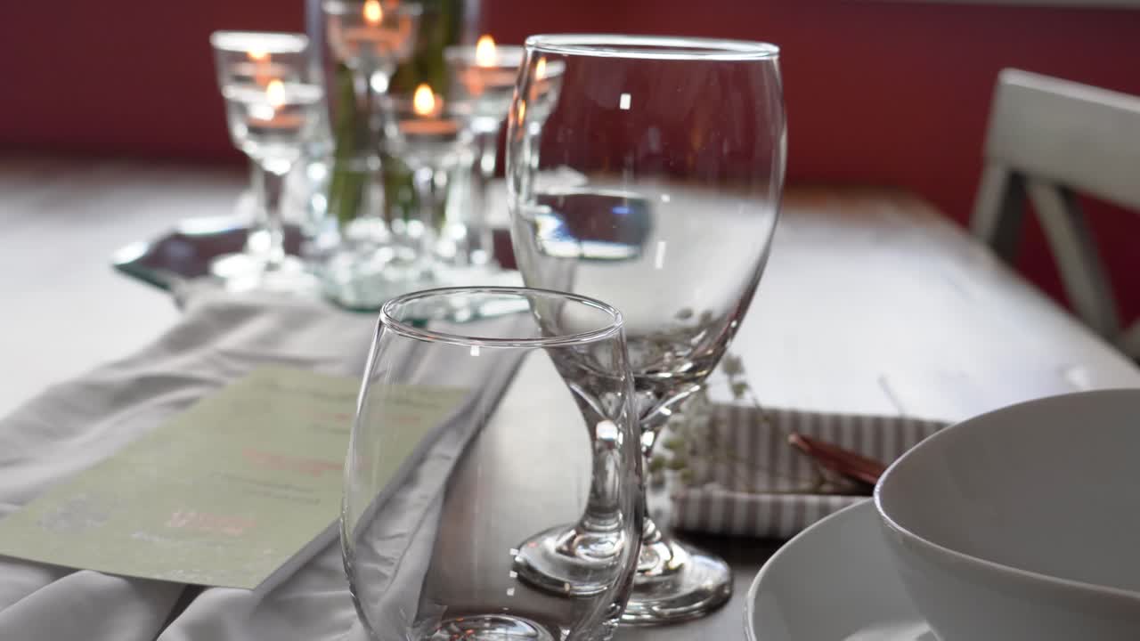 Romantic Dining Room Table Set for Dinner with White Plates and Gold Silverwhere with Beautiful Flowers and Lit Candels next to Sunny Window, Gimbal Movement, Forks, Knives and Napkins