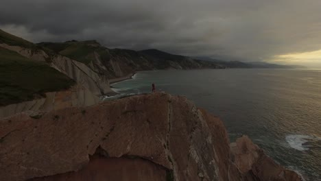 Loving-couple-kissing-on-rocky-cliff-near-sea