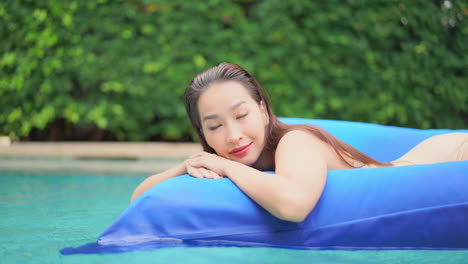 Hermosa-Mujer-Asiática-Relajándose-En-El-Colchón-Inflable-Del-Salón-De-La-Piscina-De-Aire